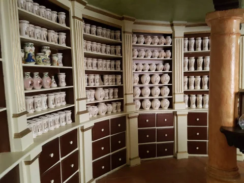 Estanteria neoclásica con colección de albarelos, vasijas y tarros cilíndricos de cerámica