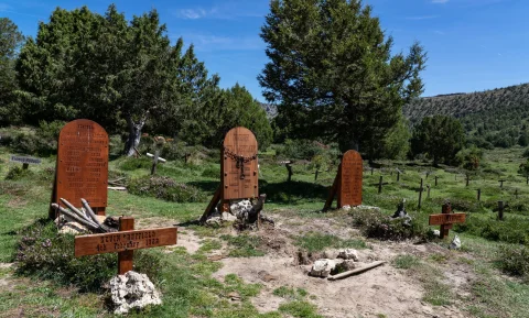 Conjunto de grandes lápidas de madera y cruces conmemorativas junto a los árboles en el Cementerio de Sad Hill