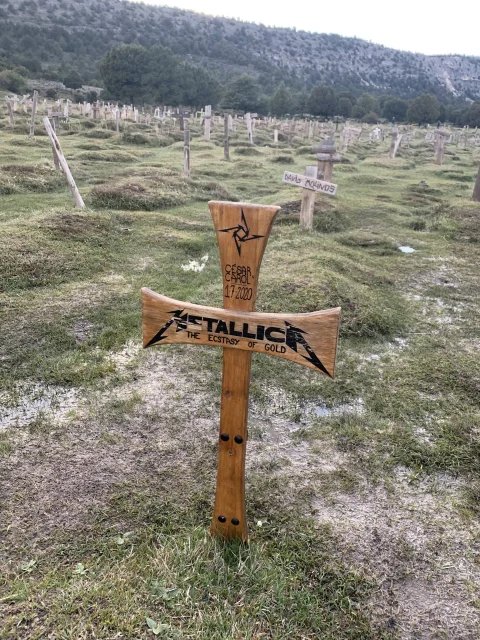 Primer plano de la famosa cruz de Metallica con el mar de tumbas en el Cementerio de Sad Hill