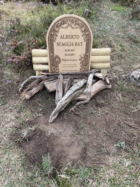 Tumba conmemorativa apadrinada con epitafio en italiano y orla grabada en la madera
