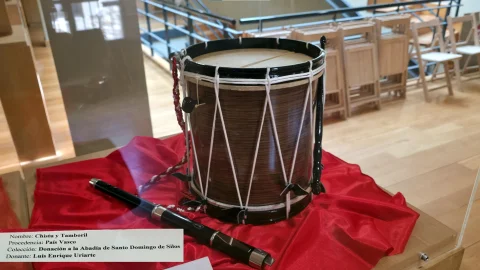 Chistu y tamboril tradicional del País Vasco expuestos sobre tela roja en vitrina del Museo de Santo Domingo de Silos