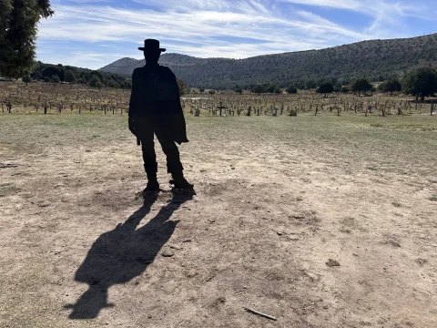 Silueta metálica a contraluz de El Rubio (Clint Eastwood) con poncho y sombrero dominando el Cementerio de Sad Hill