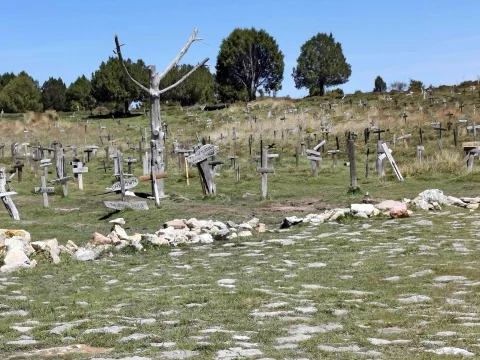 Vista desde el ruedo empedrado hacia el árbol central y el mar de cruces en el Cementerio de Sad Hill bajo cielo azul