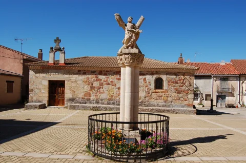Estatua de Santo André sobre columna de piedra frente a la ermita en la plaza de Contreras