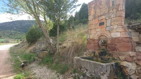 Monumento fuente a Félix Rodríguez de la Fuente con pilón y fuente rústica anexa al fondo