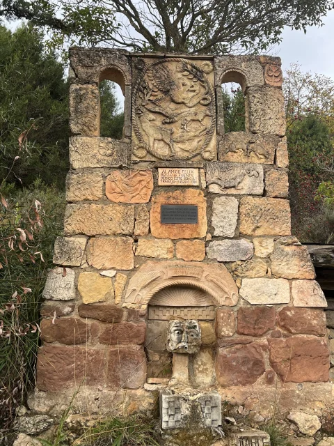 Monumento y fuente de piedra en memoria de Félix Rodríguez de la Fuente con relieves de fauna