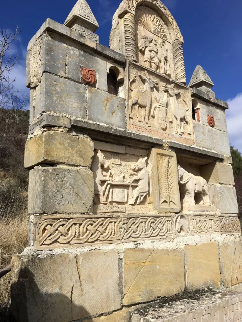 Monumento de piedra tallado con relieves y escenas dedicadas a la figura del burro