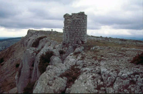 Torreón circular en ruinas sobre el escarpe rocoso del castillo de Carazo bajo cielo nublado