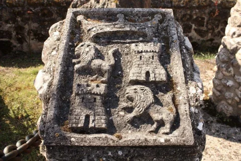 Escudo heráldico de piedra tallado con leones rampantes torres y corona en Contrera