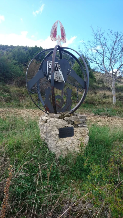 Escultura esférica de metal con silueta de corazón y alas