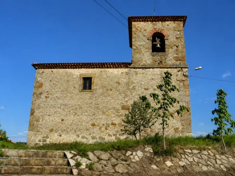 Vista lateral del muro de piedra y campanario de la Iglesia de Santa María