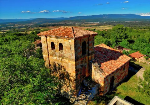 Torre de sillería y tejado de la iglesia con vistas al valle de fondo