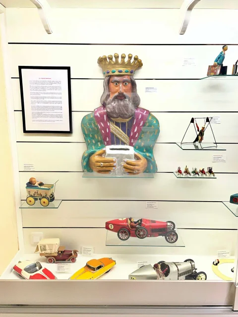Buzón de Rey Mago y coches de carreras clásicos en vitrina del Museo del Juguete de Barbadillo