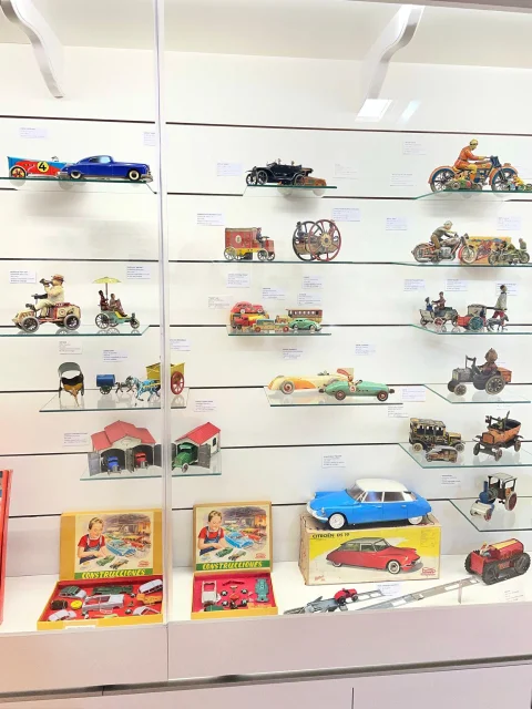 Colección de vehículos a escala y juegos de construcción en vitrina del Museo del Juguete