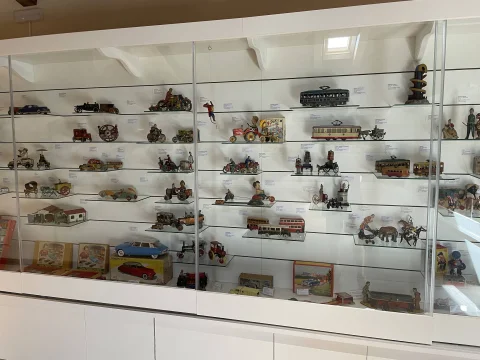 Vitrina con coches, trenes y figuras de hojalata clásica en el Museo del Juguete de Barbadillo