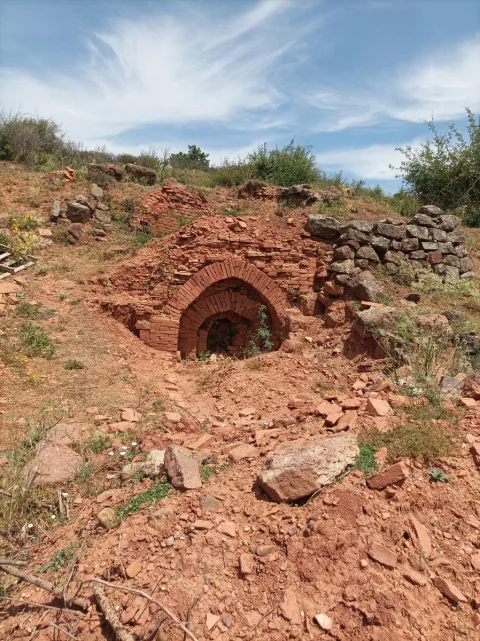 Estructura de horno de ladrillo rojo excavado en la ladera del yacimiento tradicional La Tejera
