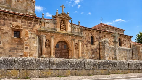 Portada clasicista con hornacinas y crucero de piedra en la iglesia de San Pedro Apóstol de Barbadillo del Mercado