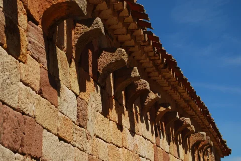 Detalle de los canecillos y modillones de piedra bajo el alero de la ermita de San Juan Bautista