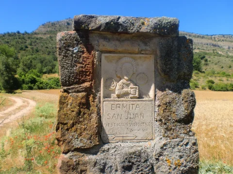 Hito de piedra con placa indicadora hacia la ermita visigótica de San Juan en Barbadillo del Mercado