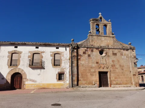 Iglesia de la Trinidad y casa anexa bajo cielo despejado en Barbadillo del Mercado