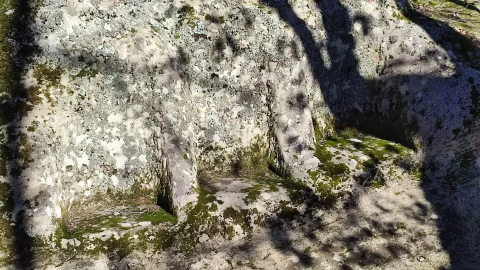 Detalle de los tres asientos esculpidos en la roca con musgo en el Altar Céltico de Gete