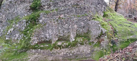 Tres asientos tallados en la roca cubiertos de musgo en el Altar de los Tres Tronos en Gete