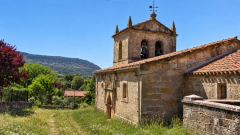 Muro lateral y torre campanario de la iglesia de la Inmaculada Concepción con paisaje en Gete
