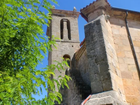 Detalle del campanario de piedra con escalera exterior adosada y contrafuerte en la iglesia de Pinilla