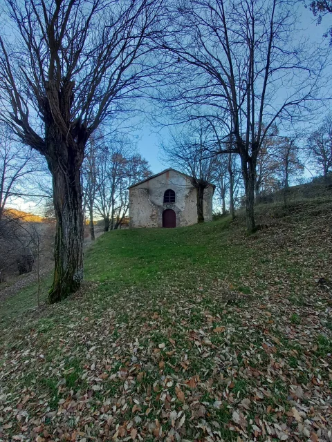 Ermita rural de San Miguel en ladera boscosa cubierta de hojas secas en Pinilla de los Barruecos