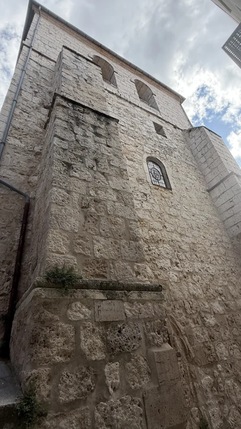 Vista inferior del muro exterior de piedra y contrafuerte de la Iglesia de Santa Águeda