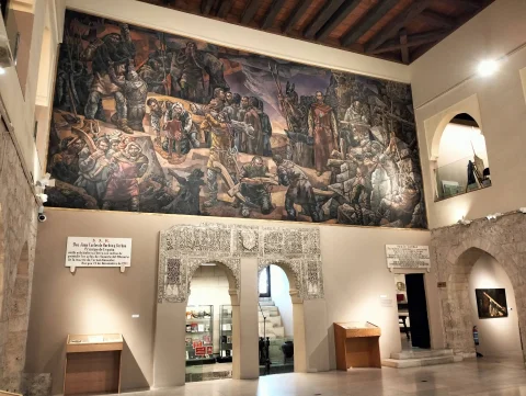 Mural monumental de Vela Zanetti sobre la historia de Castilla presidiendo la sala con yeserías mudéjares
