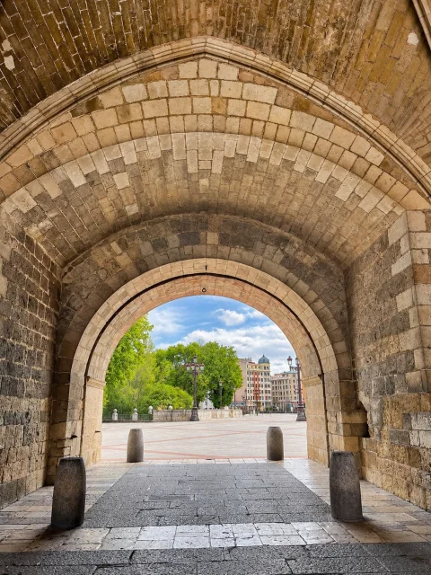 Vista a través del arco de medio punto de acceso exterior hacia el Puente de Santa María y el arbolado