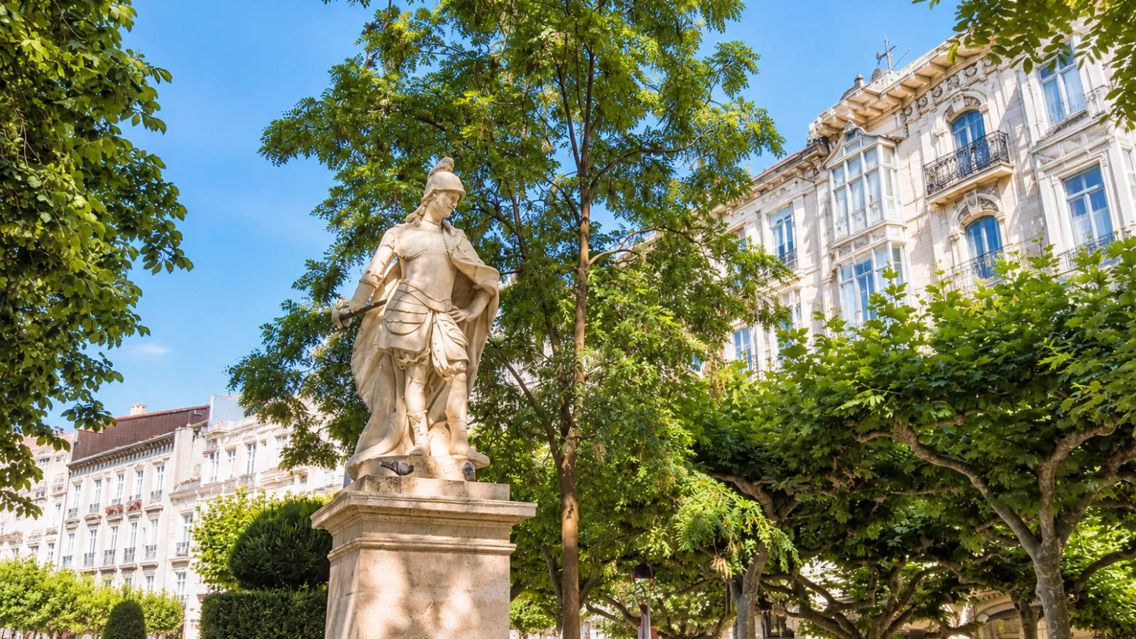 Escultura de Fernando I el Magno sobre pedestal con el arbolado