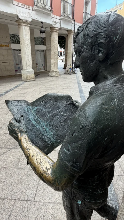 Detalle del periódico y del antebrazo pulido por el roce en la estatua El lector de prensa de Burgos