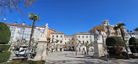 Panorámica de la plaza peatonal flanqueada por estatuas de reyes sobre pedestales y fachadas burgalesas