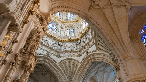 Detalle de relieves escultóricos, escudos y ventanales con arcos de medio punto en el interior del crucero
