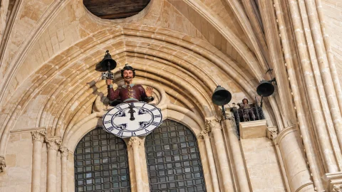 El Papamoscas sobre el reloj gótico junto al Martinillo y sus campanas en la pared de piedra
