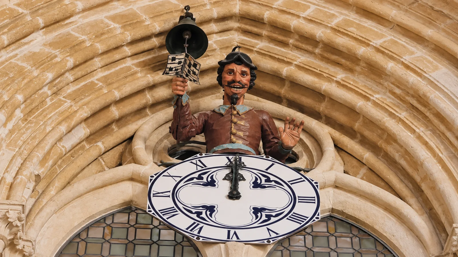 Autómata del Papamoscas sobre la esfera del reloj tocando la campana de las horas