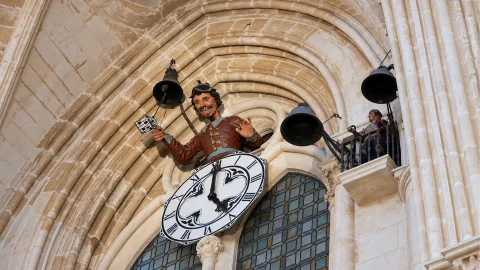 Vista en contrapicado de los autómatas del Papamoscas y el Martinillo con las campanas del reloj catedralicio