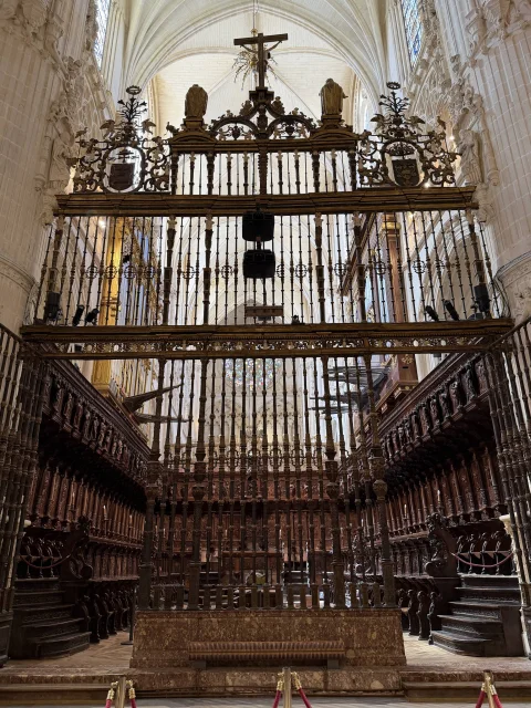 Monumental reja renacentista de Juan Bautista Celma con remate del Calvario y escudos que cierra el coro