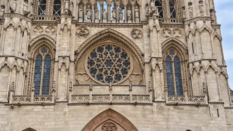 Gran rosetón gótico con tracería estrellada calada, ventanales apuntados y galería de los Reyes