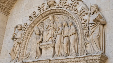 Remate superior plateresco de la Portada de la Pellejería con la Virgen en trono, obispo donante y santos