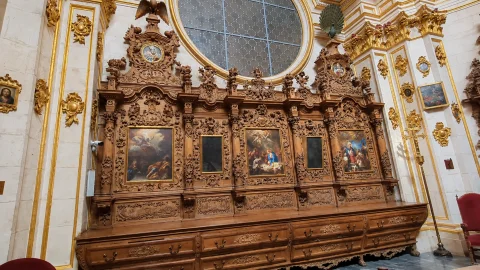 Gran cajonería barroca de nogal tallado con pinturas bíblicas encastradas y ventanal circular