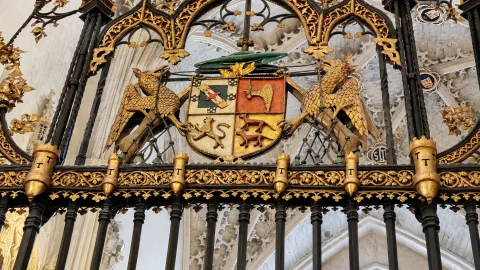 Escudo heráldico episcopal del obispo Luis de Acuña flanqueado por grifos dorados en la reja gótica