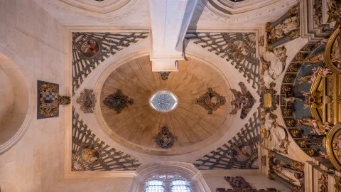 Vista cenital de la cúpula oval sobre trompas decoradas con motivos abanicados, tondos de obispos y linterna