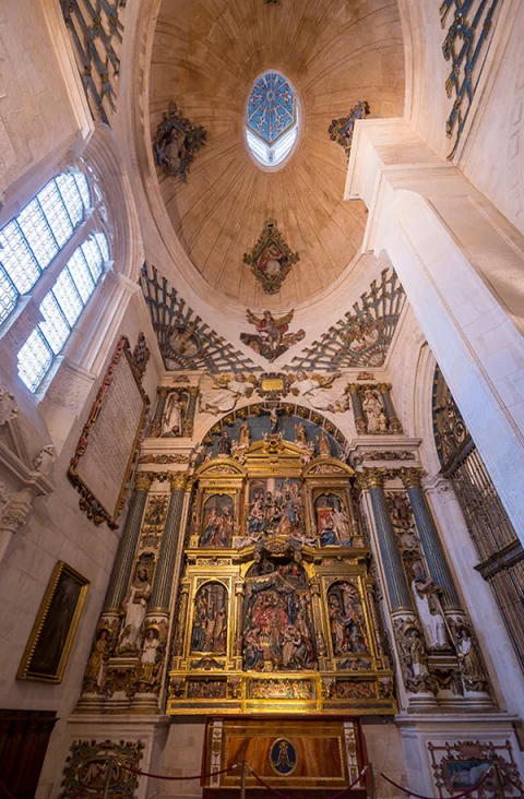 Vista vertical del retablo mayor manierista enmarcado en arco triunfal y cúpula con linterna oval