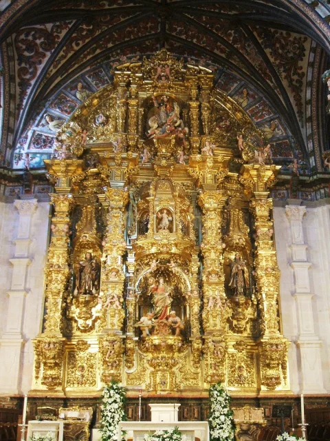 Vista frontal del retablo mayor churrigueresco dorado en madera tallada presidido por santa Tecla