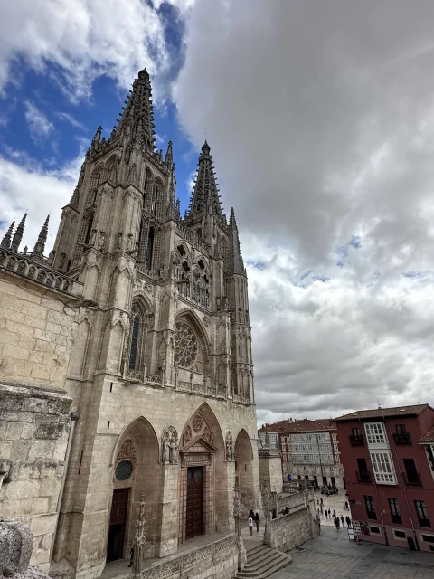 Fachada principal y agujas góticas de la Catedral de Burgos bajo un cielo azul despejado
