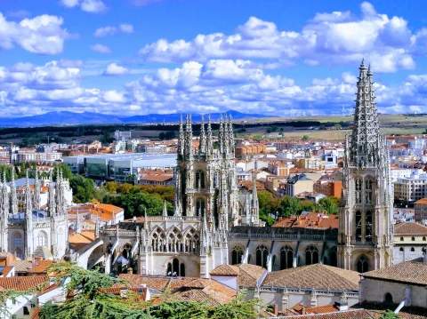Torres y cimborrio de la Catedral de Burgos rodeados de tejados bajo un cielo azul