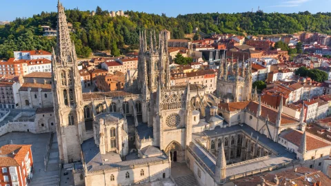 Vista aérea de la Catedral de Burgos mostrando el claustro, cimborrio y colina del Castillo al fondo